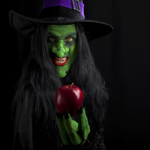 Witch and her red poison apple, dark background. © davidevison ...